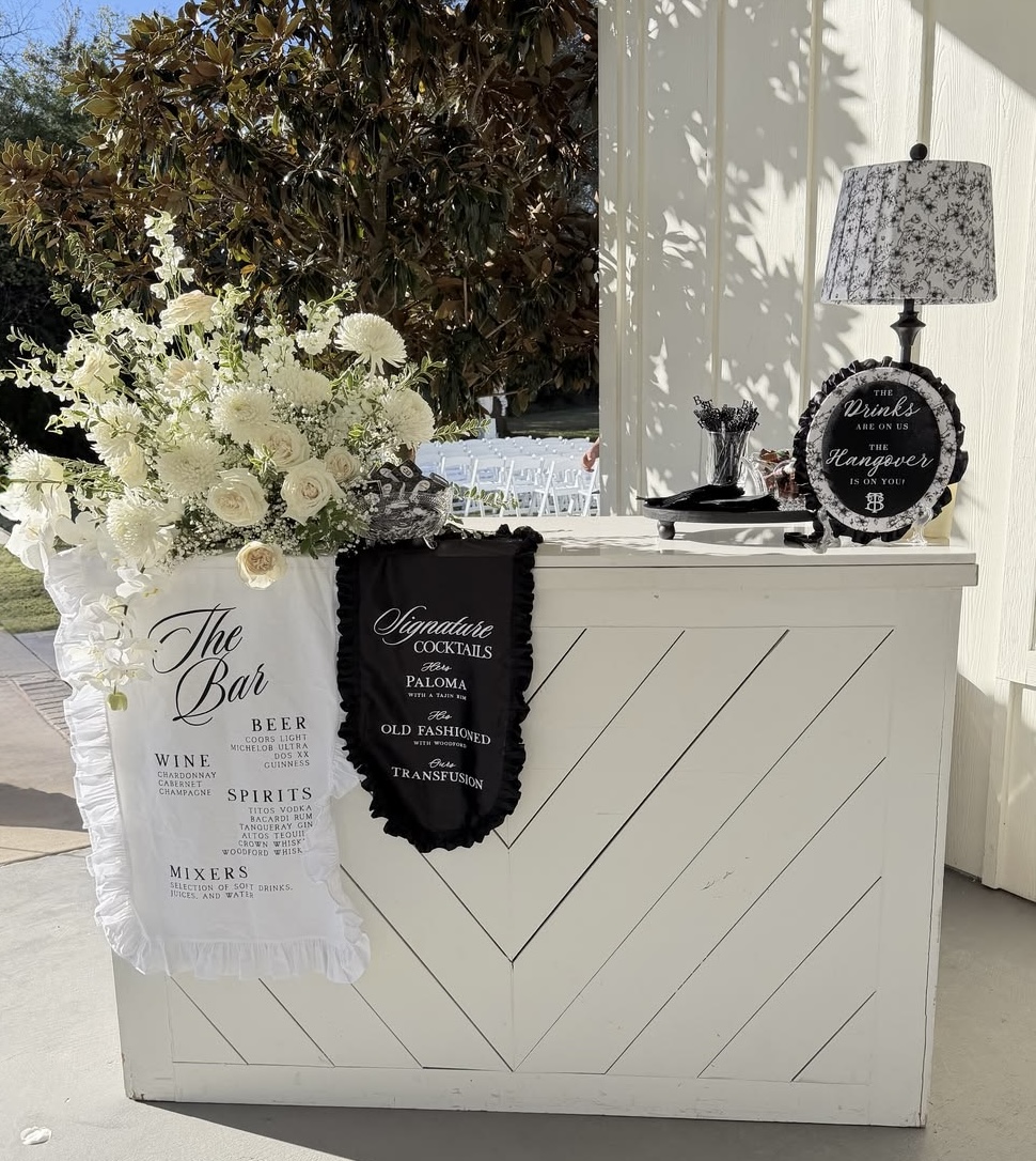 The Bar menu and Signature Cocktails pillows on a white herringbone bar